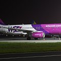 Wizz Air czekający na swój lot na płycie postojowej.